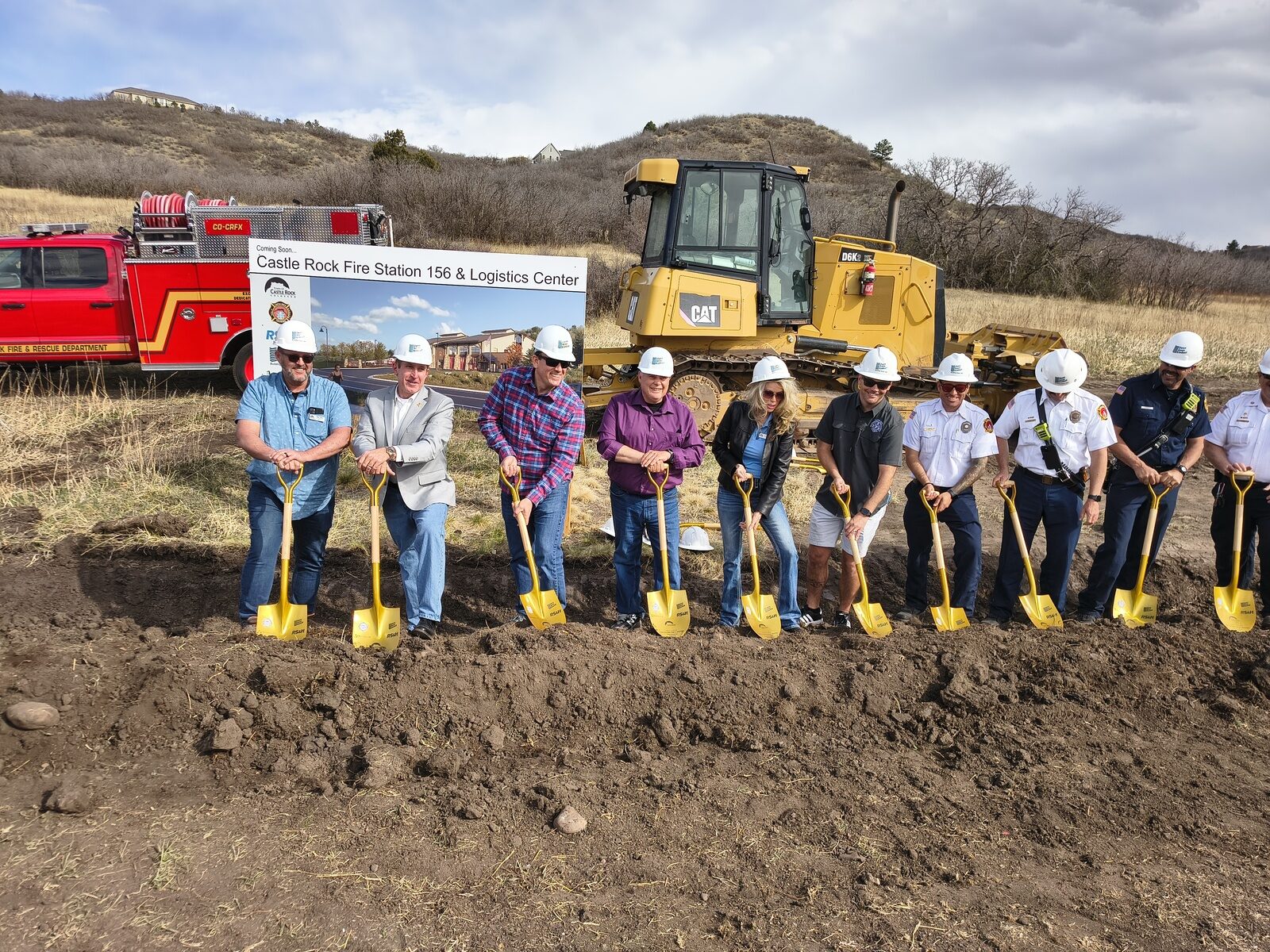 Laura Cavey with Town officials and Castle Rock Fire and Rescue leadership in white hard hats, turning dirt with gold shovels at the Fire Station 156 groundbreaking on Castle Oaks Drive